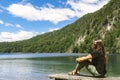 Young woman observes and relaxes sitting on the dock