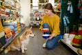 Young woman offering her lovely dog to choose new feed bowl