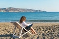 Young woman in office clothes with a laptop on the beach on a background of the sea in a summer sunny day. Concept Royalty Free Stock Photo