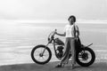 Young woman and an old antique bicycle standing in the edge of the lake in black and white on nature landscape background Royalty Free Stock Photo