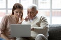 Young woman and older man using laptop together at home Royalty Free Stock Photo