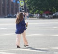 A young woman with an open bottle of sparkling wine in her hand walks down the street Royalty Free Stock Photo