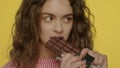 Young woman opening chocolate bar. Portrait of happy girl eating chocolate Royalty Free Stock Photo