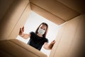 Young woman opening the huge postal package wearing protective face mask, contactless delivery Royalty Free Stock Photo