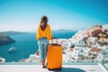 Young woman with orange travel suitcase on Santorini island in Greece, Happy moment with young woman rear view tourist as orange Royalty Free Stock Photo