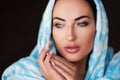 Young woman of oriental appearance in a blue scarf. Beauty portrait of arabian or indian girl with perfect makeup Royalty Free Stock Photo