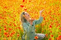 Young woman outdoor in poppy field on poppies background. Girl in the field of spring blossom flowering meadow. Royalty Free Stock Photo