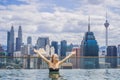 Young woman in outdoor swimming pool with city view in blue sky. Rich people Royalty Free Stock Photo