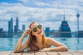 Young woman in outdoor swimming pool with city view in blue sky Royalty Free Stock Photo