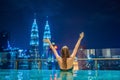 Young woman in outdoor swimming pool with city view at night Royalty Free Stock Photo