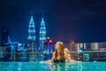 Young woman in outdoor swimming pool with city view at night Royalty Free Stock Photo