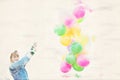 Young woman outdoors holding colorful balloons