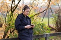 Young woman outdoors listening to music with wireless bluetooth headphones and mobile smart phone Royalty Free Stock Photo