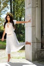 Young woman outside leaning on a wall