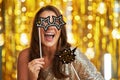 Young woman over gold background with photo booth accessories