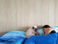 Young woman owner is lying and sleeping with pug dog in bed Royalty Free Stock Photo