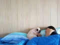 Young woman owner is lying and sleeping with pug dog in bed Royalty Free Stock Photo