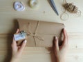 Young woman, owner of sewing small business wrapping an parcel for delivery. Gift wraping idea.