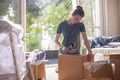 Young woman packaging carton boxes and planning to move to a new house Royalty Free Stock Photo