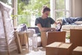 Young woman packaging carton boxes and planning to move to a new house Royalty Free Stock Photo