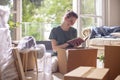 Young woman packaging carton boxes and planning to move to a new house Royalty Free Stock Photo