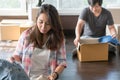 Young woman packing cloth into cardboard box prepare to move out to new location