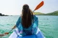 Young woman paddling a canoe along the shore of an idyllic islan Royalty Free Stock Photo