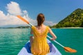 Young woman paddling a canoe during vacation in Flores Island