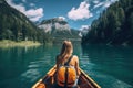 Young woman paddling a kayak on Lake braies in south tyrol, italy, Female kayaking on a mountain lake, rear view, no face revealed