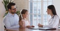 Woman paediatrician and kid girl patient talk at paediatric checkup