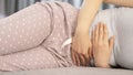 Young woman in pain lying on bed at home. stomachache Royalty Free Stock Photo