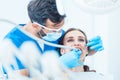 Young woman during painless oral treatment in the modern dental clinic