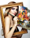 Young woman painter in golden frame with color pallet and paint Royalty Free Stock Photo