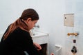 Young woman painting bathroom ceramic wall tiles ,do it your self ,renovation