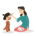 Woman painting the face of the girl in the tiger costume