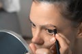 Young woman is painting contour of eyebrows using pencil before painting them. Royalty Free Stock Photo