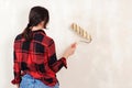 Young woman painting wall in room. Woman paints walls with a roller. Apartment renovation Royalty Free Stock Photo