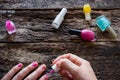 Young woman paints her nails pink polish on table Royalty Free Stock Photo