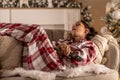 A young woman in pajamas fell asleep on the sofa in front of the TV while watching the Christmas broadcast Royalty Free Stock Photo