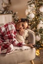 A young woman in pajamas fell asleep on the sofa in front of the TV while watching the Christmas broadcast Royalty Free Stock Photo