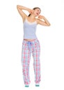 Young woman in pajamas stretching and yawing