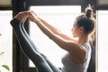 Young woman in Paripurna Navasana pose, home interior, close up