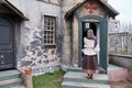Young woman parishioner stands with her back and prays at the door of a medieval church. Halloween gothic vintage costume