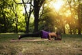Young woman in park plank exercise pose