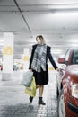 Young woman in a parking lot near a car. Girl after shopping.