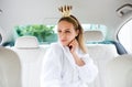 Young woman with party accessories sitting in car, having fun.