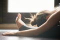 Young woman in paschimottanasana pose, home interior background, Royalty Free Stock Photo