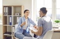 Young woman patient talking to a male doctor in his office in clinic during medical examination. Royalty Free Stock Photo