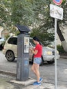 Vladivostok, Russia, August, 24, 2023. Young woman pays for paid parking on Posyetskaya Street in Vladivostok