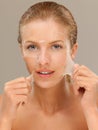 Young woman peeling off a facial mask smiling Royalty Free Stock Photo